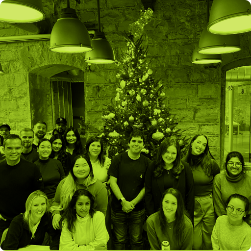 People posing for an indoor group photo with a Christmas tree in the background